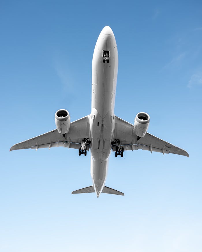 Low angle shot of an airplane flying against a clear blue sky in Morrisville, NC.