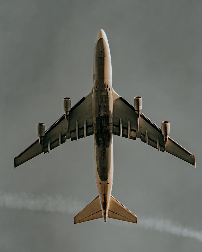 Aerial shot of a commercial airplane soaring against a clear sky, showcasing aviation dynamics.