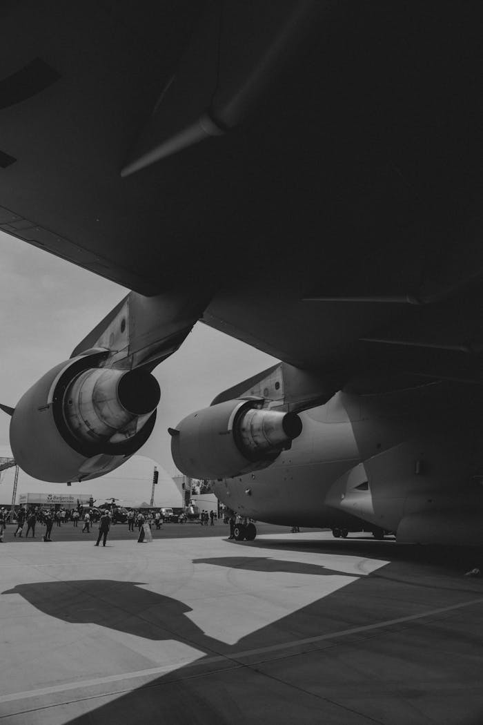 Monochrome image of an aircraft and its engine during an open air show.